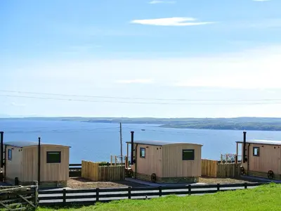 a row of mobile homes next to a body of water at Little Beach - Uk5997 in Carsluith