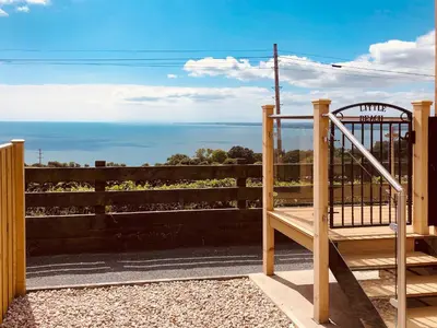 a wooden gate with a view of the ocean at Little Beach - Uk5997 in Carsluith