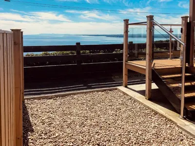 a wooden fence with a view of the ocean at Little Beach - Uk5997 in Carsluith