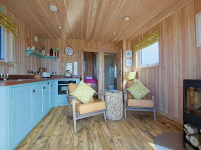 a kitchen with wooden walls and a wooden floor at Little Willow - Uk5998 in Carsluith