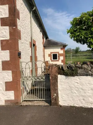 a gate to a building with a dog house at The Annex, countryside escape in Dumfries