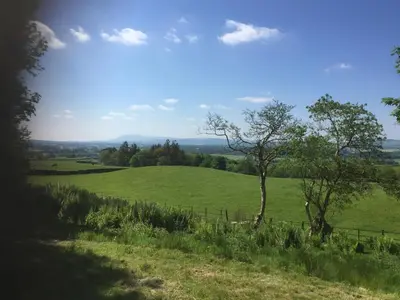 a field of green grass with a fence and trees at The Annex, countryside escape in Dumfries