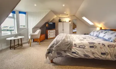 a bedroom with a bed and a television in a attic at The View in Garlieston