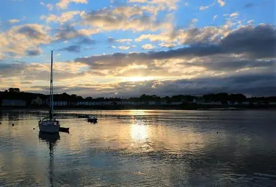 a sail boat sitting in the water at sunset at The View in Garlieston