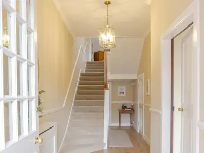a staircase in a home with a chandelier at Blair Terrace in Portpatrick