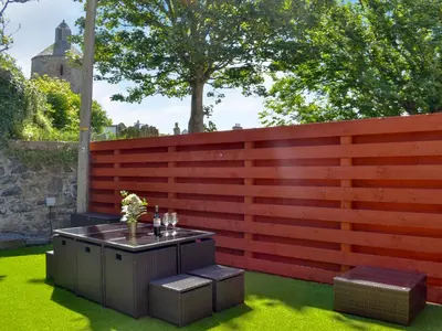 a fence with a table on the grass at Blair Terrace in Portpatrick