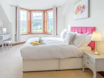 a bedroom with a large white bed with a tray on it at Blair Terrace in Portpatrick