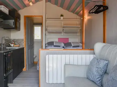a tiny house with a couch in a kitchen at The Rocking Lodge in Threlkeld