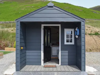 a blue shed with a door in the middle at The Rocking Lodge in Threlkeld