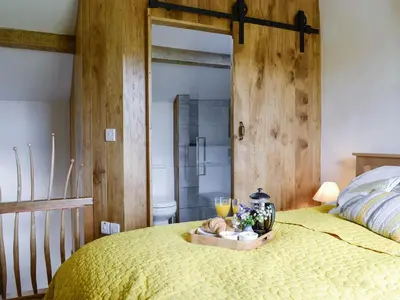 a bedroom with a bed with a tray of food at Springlea Cottage in Dean