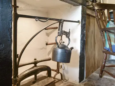 an old metal pot hanging on a wall at Springlea Cottage in Dean