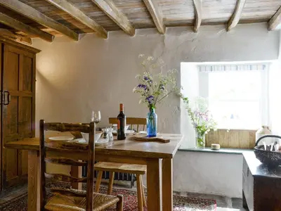a dining room with a table with a vase of flowers at Springlea Cottage in Dean