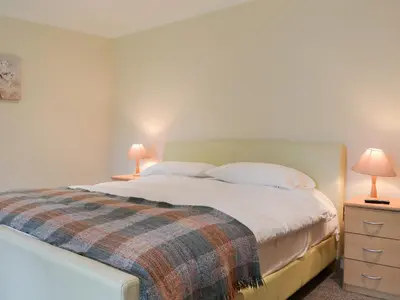 a bedroom with a large bed with two lamps at Lucy's At The Grange - Uk11519 in Mockerkin
