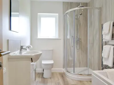 a bathroom with a shower and a toilet and a sink at Lucy's At The Grange - Uk11519 in Mockerkin