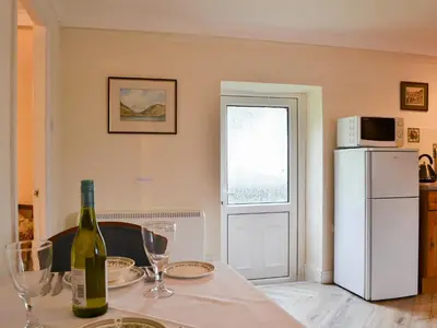 a kitchen with a table with a bottle of wine at Lorna's At The Grange - Uk11565 in Mockerkin