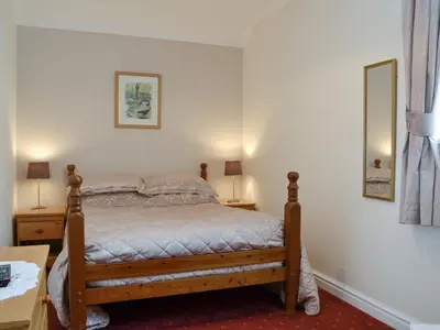 a bedroom with a bed and two lamps and a table at Lorna's At The Grange - Uk11565 in Mockerkin