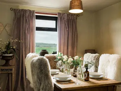 a dining room with a table and a window at Woodend in Maxwelltown