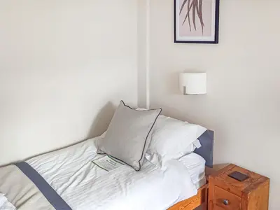 a bed with a pillow on it with a night stand at Wanderers Rest in Keswick