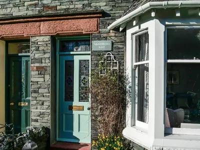 a house with a blue door and a window at Wanderers Rest in Keswick