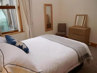 a bedroom with a bed and a dresser and a mirror at Number 48 in Dumfries