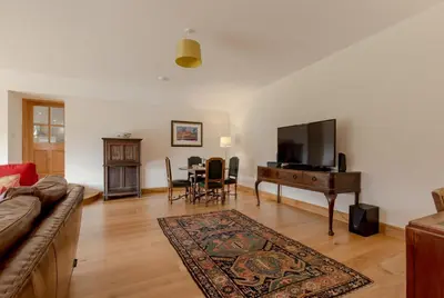 a living room with a couch and a television and a table at Pant Farmhouse in Ayr
