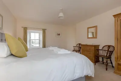 a bedroom with a large white bed and a desk at Pant Farmhouse in Ayr