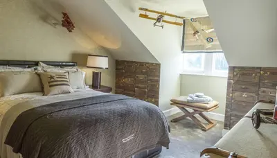 a bedroom with a bed and a table and a window at Ram Lodge in Moffat