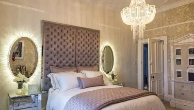a bedroom with a large bed and a chandelier at Ram Lodge in Moffat