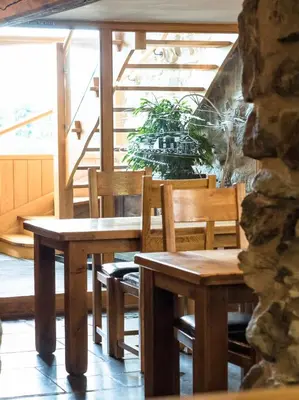 a table and chairs in a room with stairs at The Wayside and Whisky Barn in Whitbeck
