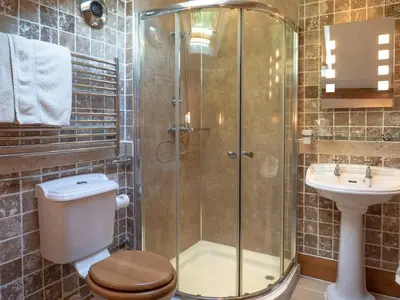 a bathroom with a shower and a toilet and a sink at The Wayside and Whisky Barn in Whitbeck