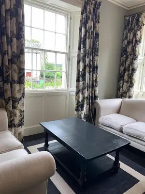 a living room with a coffee table and a window at Dovenby Apartment- great base for exploring Lake District in Cockermouth