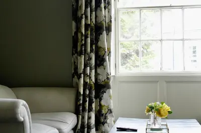 a living room with a couch and a window at Dovenby Apartment- great base for exploring Lake District in Cockermouth