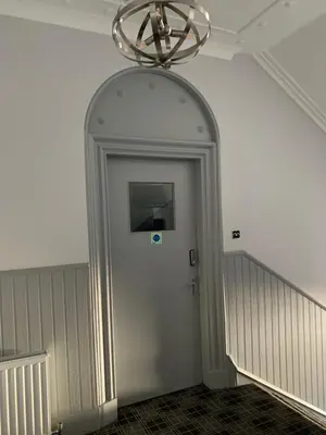 a hallway with a door with a chandelier above it at The Royal Hotel in Stranraer