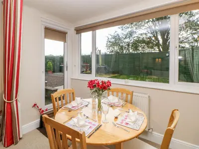 a dining room with a table and a window at Berrymoor Cottage in Brampton