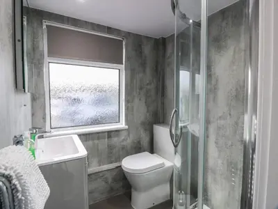 a bathroom with a toilet and a sink and a window at Mardan in Dumfries