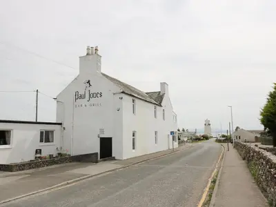 a white building on the side of a street at Mardan in Dumfries
