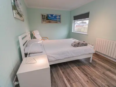 a small bedroom with a bed and a desk at Mardan in Dumfries