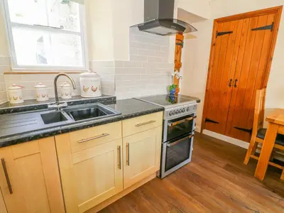 a kitchen with a sink and a stove at Tilberthwaite Farm Cottage in Coniston