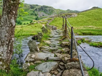 a stone path next to a river at Tilberthwaite Farm Cottage in Coniston