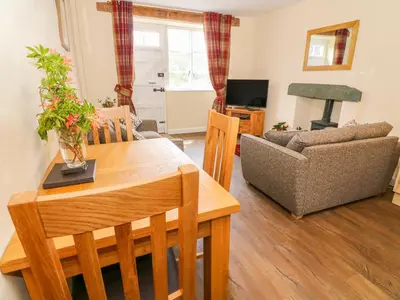 a living room with a table and a couch at Tilberthwaite Farm Cottage in Coniston