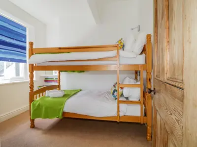 two bunk beds in a room with a door at Sefton House in Keswick