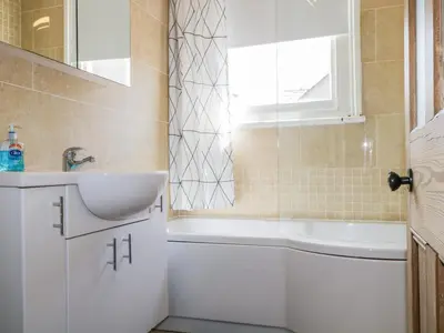 a bathroom with a sink and a bath tub and a sink at Sefton House in Keswick
