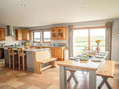 a kitchen with a table and a counter top at Corsewall Castle Farm Lodges in Stranraer