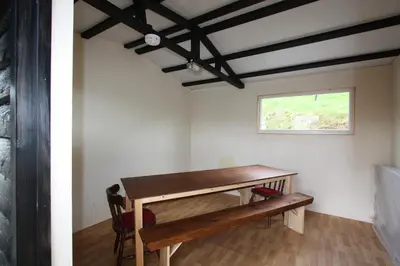 a room with a wooden table and a window at The White Horse Inn Bunkhouse in Threlkeld