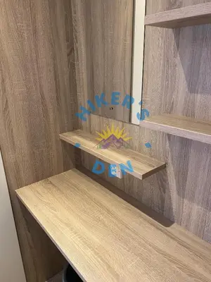 a wooden shelf with a mirror in a room at Hikers Den, Brigham, Cockermouth, Cumbria in Cockermouth