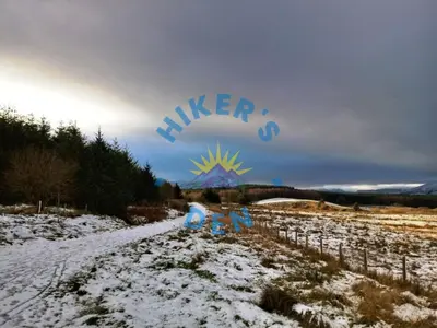 a snow covered road with a sign that says killer at Hikers Den, Brigham, Cockermouth, Cumbria in Cockermouth