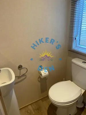 a bathroom with a white toilet and a sink at Hikers Den, Brigham, Cockermouth, Cumbria in Cockermouth