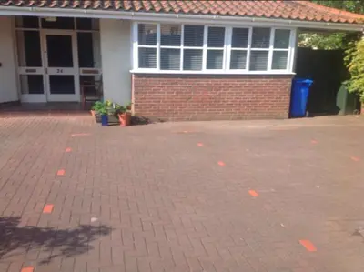 a brick parking lot in front of a brick house at The Clan Macfarlane Apartment in Kilmarnock