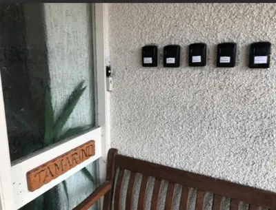 a wall with three cell phones on a wall with a bench at The Clan Macfarlane Apartment in Kilmarnock