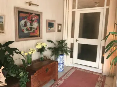 a room with a table with flowers and a window at The Clan Macfarlane Apartment in Kilmarnock